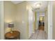 Hallway featuring white tile floors, a small side table, and two doorways at 3540 Cockatoo Dr, New Port Richey, FL 34652