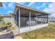 Enclosed lanai with screened windows, exterior brick pavers, and lawn at 3540 Cockatoo Dr, New Port Richey, FL 34652
