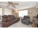 Comfortable living room with a ceiling fan, large window, a comfortable leather sofa, and tile flooring at 3540 Cockatoo Dr, New Port Richey, FL 34652