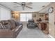 Cozy living room with a ceiling fan, large window, a comfortable leather sofa, and tile flooring at 3540 Cockatoo Dr, New Port Richey, FL 34652