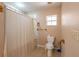 Bathroom with a toilet, shower with neutral striped curtain, and a small window that provides natural light at 3823 N 56Th St, Tampa, FL 33619