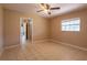 Bedroom featuring a window, a ceiling fan, and a view of the hallway and bathroom enhancing its appeal at 3823 N 56Th St, Tampa, FL 33619