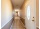Long hallway with tiled flooring that leads to a decorative front door and a glimpse of other rooms at 3823 N 56Th St, Tampa, FL 33619