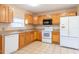 Well-lit kitchen featuring wooden cabinets, modern appliances, and neutral countertops with tiled flooring at 3823 N 56Th St, Tampa, FL 33619