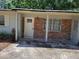 Exterior view showcasing the front entrance with a brick accent wall and weathered paint at 4708 W Ballast Point Blvd, Tampa, FL 33611