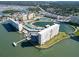 Aerial view showcases waterfront condos with a scenic pond, tennis courts, and lush green spaces at 4725 Cove Cir # 601, St Petersburg, FL 33708