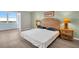 Bright bedroom with neutral decor, two bedside tables, and a glimpse of the outside view at 4725 Cove Cir # 601, St Petersburg, FL 33708