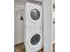 Efficient laundry area with stackable washer and dryer units and shelving at 4725 Cove Cir # 601, St Petersburg, FL 33708