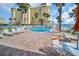 Outdoor pool area with brick pavers, chaise lounges, and a view of the ocean at 4725 Cove Cir # 601, St Petersburg, FL 33708