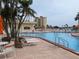 Community pool featuring lounge chairs, palm trees, and distant views of the bay and harbor at 4725 Cove Cir # 601, St Petersburg, FL 33708