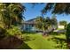 Landscaped backyard with screen enclosed pool and lush tropical foliage at 4997 W Breeze Cir, Palm Harbor, FL 34683
