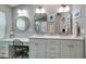 Bright bathroom with double sink vanity, granite countertop, and decorative mirrors at 4997 W Breeze Cir, Palm Harbor, FL 34683