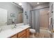 Cozy bathroom featuring a wood vanity, tub with shower, and tasteful decor at 4997 W Breeze Cir, Palm Harbor, FL 34683