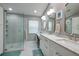 Bathroom with dual sinks, vanity, walk-in shower with glass doors and modern fixtures at 4997 W Breeze Cir, Palm Harbor, FL 34683