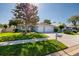 Beautiful single-story home featuring a lush green lawn, mature trees, and a two-car garage with a large driveway at 4997 W Breeze Cir, Palm Harbor, FL 34683