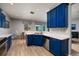 Modern kitchen boasting vibrant blue cabinets, stainless steel appliances, and ample counter space at 4997 W Breeze Cir, Palm Harbor, FL 34683