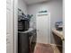 Modern laundry room with grey washer and dryer and functional shelving at 4997 W Breeze Cir, Palm Harbor, FL 34683