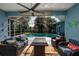 Relaxing screened-in patio with comfortable seating, a ceiling fan, and a view of the sparkling pool at 4997 W Breeze Cir, Palm Harbor, FL 34683