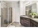 Well lit bathroom with a granite topped vanity and glass shower stall featuring tile surround at 5276 6Th N Way, St Petersburg, FL 33703