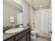 Well-lit bathroom with a granite-topped vanity, shower with curtain and tile floors at 5276 6Th N Way, St Petersburg, FL 33703