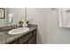 Elegant bathroom with a granite countertop, decorative flowers, and a well-lit mirror at 5276 6Th N Way, St Petersburg, FL 33703