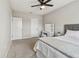 Neutral-toned bedroom with plush carpet, ceiling fan, vanity, and bright natural light from the window at 5276 6Th N Way, St Petersburg, FL 33703