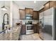 Well-equipped kitchen with stainless steel appliances, granite countertops, and dark wood cabinets at 5276 6Th N Way, St Petersburg, FL 33703