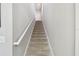 Carpeted staircase leading to the upper level of the home with a white handrail at 5276 6Th N Way, St Petersburg, FL 33703