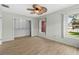 Sun-filled bedroom featuring wood-look flooring, ceiling fan, closet, and canal view at 543 Crystal Dr, Madeira Beach, FL 33708