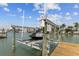 Boat lift on wooden dock offering direct access to the water with clear skies and stunning canal views at 543 Crystal Dr, Madeira Beach, FL 33708