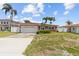 Charming coral home with a well-manicured lawn, attached garage, and beautiful blue skies at 543 Crystal Dr, Madeira Beach, FL 33708