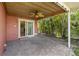Covered patio with brick pavers and ceiling fan, leads to a lush backyard at 543 Crystal Dr, Madeira Beach, FL 33708