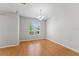 An empty dining room with laminate floors, a hanging chandelier, and a large window at 581 Oceanview Ave, Palm Harbor, FL 34683