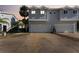 Exterior of townhome featuring a two-car garage, with palm trees and landscaped yard at 581 Oceanview Ave, Palm Harbor, FL 34683