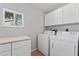 Well-equipped laundry room with a window, ample storage, washer and dryer at 581 Oceanview Ave, Palm Harbor, FL 34683