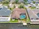 Aerial view of home with screened-in pool, lawn, and boat dock in waterfront neighborhood at 5816 Dory Way, Tampa, FL 33615