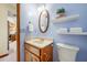 Bathroom featuring floating shelves, vanity, and blue walls at 5816 Dory Way, Tampa, FL 33615