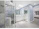 Bathroom featuring double vanity, modern shower with blue accent wall, tile floors, and a linen closet at 5816 Dory Way, Tampa, FL 33615