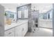 Bright bathroom featuring double vanity, modern shower with blue accent wall, and tile floors at 5816 Dory Way, Tampa, FL 33615