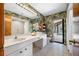 Bathroom with double sinks, a vanity, wallpaper, and direct access to the screened-in pool at 5816 Dory Way, Tampa, FL 33615