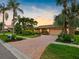 Charming home exterior with a brick driveway, lush landscaping, and a well-maintained lawn at 5816 Dory Way, Tampa, FL 33615