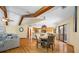 Open living and dining room area featuring exposed wood beams, hardwood floors, and a view of the kitchen at 5816 Dory Way, Tampa, FL 33615