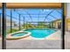 Backyard pool with screened-in enclosure featuring spa, waterfall and views of the canal and neighborhood at 5816 Dory Way, Tampa, FL 33615