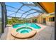 Relaxing screened-in pool area with a built-in spa, bar, and tropical landscaping perfect for outdoor entertaining at 5816 Dory Way, Tampa, FL 33615