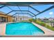 Beautiful screened-in pool with a waterfall feature and a hot tub with lush landscaping at 5816 Dory Way, Tampa, FL 33615
