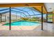 A lovely screened-in pool with hot tub and peaceful waterfall feature viewed from a covered lanai at 5816 Dory Way, Tampa, FL 33615