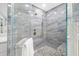 Close up of the walk in shower with blue tiling, river rock floor, and glass enclosure at 5816 Dory Way, Tampa, FL 33615