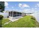 Fenced backyard featuring a screened patio, well-maintained lawn, and a storage shed for outdoor equipment at 5821 Thrush Dr, New Port Richey, FL 34652