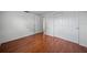 Bedroom with rich hardwood floors, featuring neutral walls and a closet with sliding doors for maximized space at 5821 Thrush Dr, New Port Richey, FL 34652