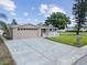 Wide shot of a home with a two-car garage, driveway, and green grass with a mailbox at 5821 Thrush Dr, New Port Richey, FL 34652